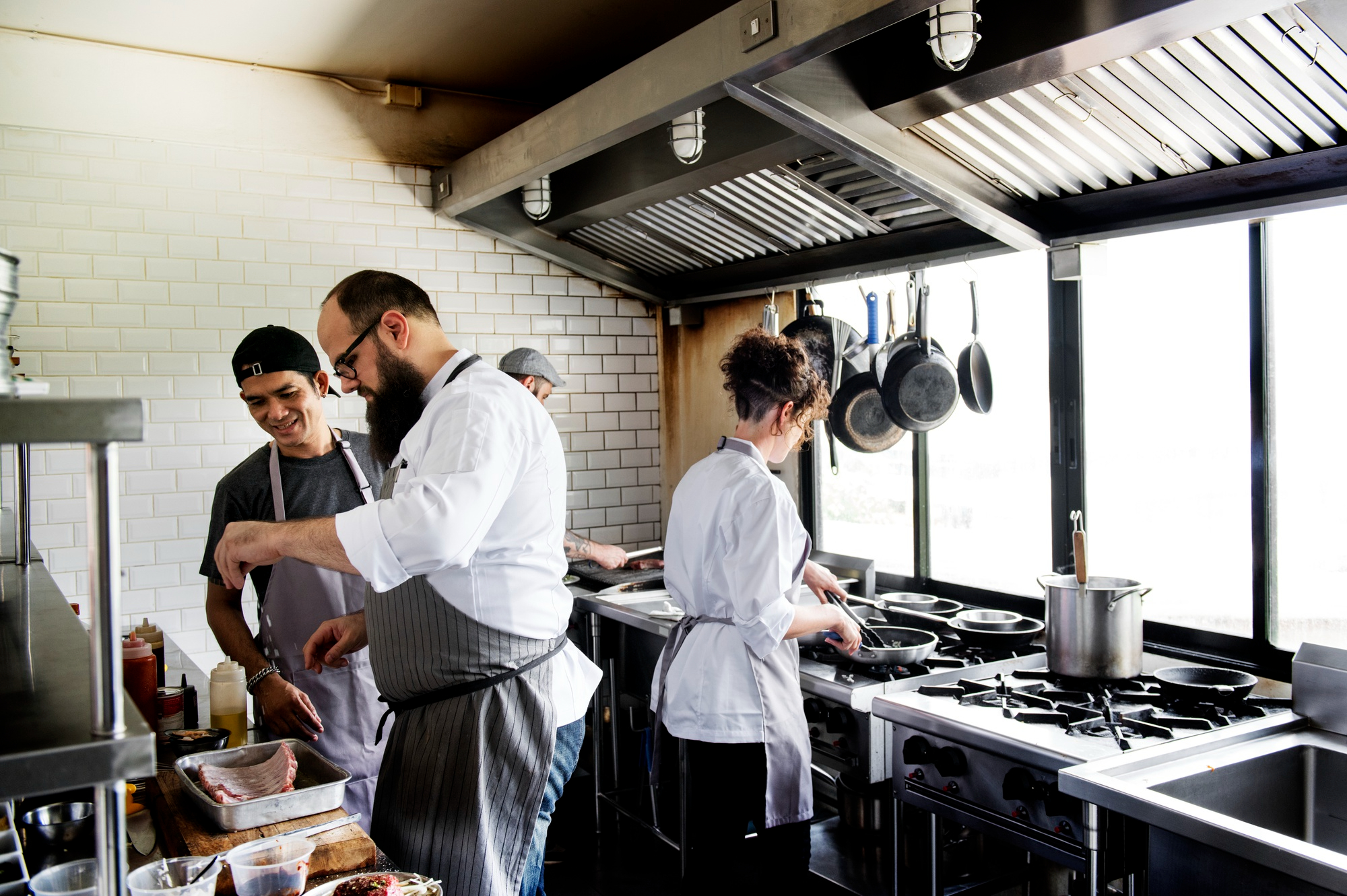 chef and staffs are working inside an organized kitchen