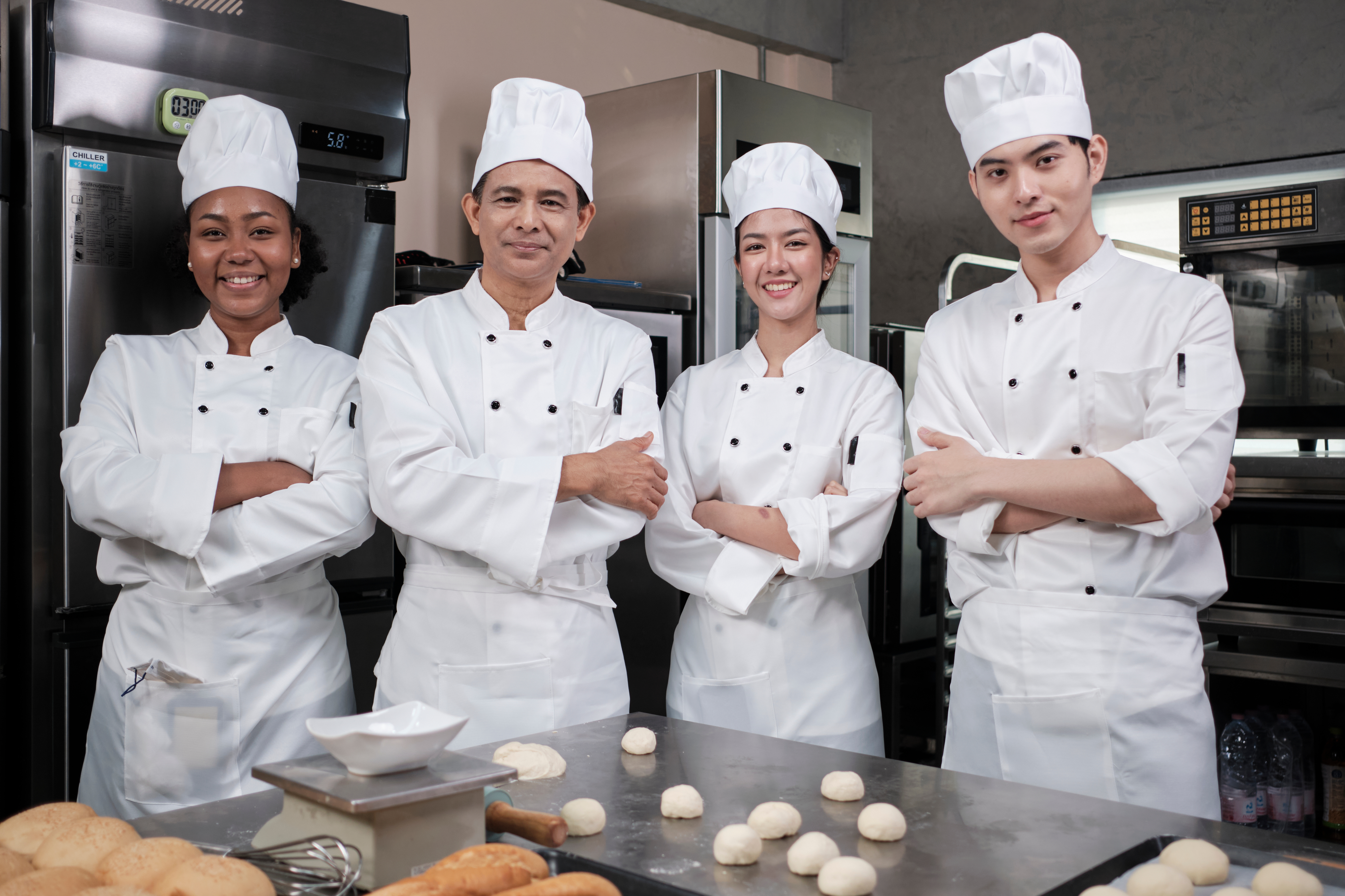 group of professional chefs standing in front of a commercial kitchen counter of a restaurant