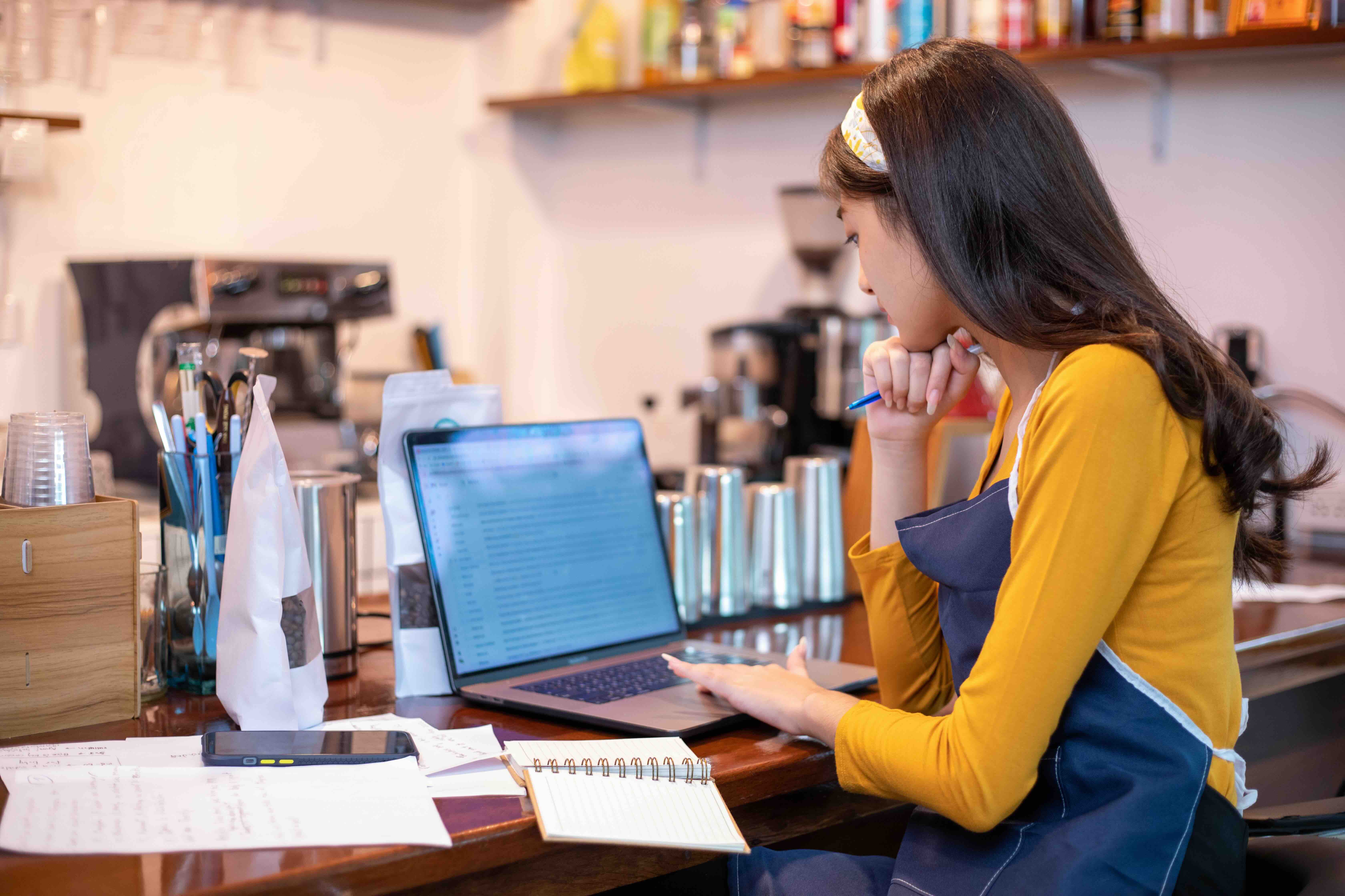 female cafe owner searching for food license application on web